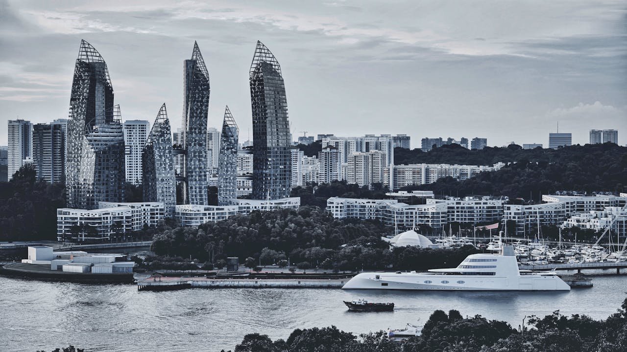 Services Contemporary skyline with unique skyscrapers by the river and a luxury yacht, showcasing urban architecture.